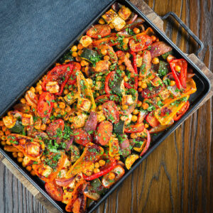 Halloumi tray bake with Mediterranean vegetables and chickpeas in a harissa and zaatar sauce.
