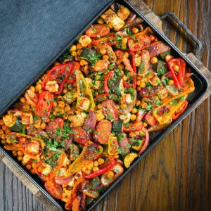 Halloumi tray bake with Mediterranean vegetables and chickpeas in a harissa and zaatar sauce.
