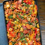 Overhead halloumi tray bake with Mediterranean vegetables, chickpeas and spicy harissa.