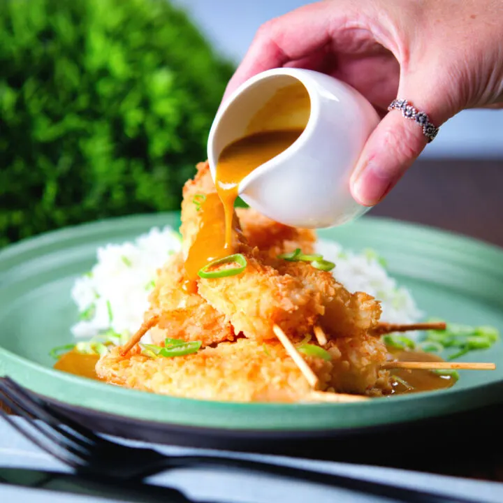 Homemade king prawn katsu curry served with white rice and spring onions.