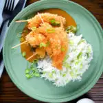 Overhead crispy king prawn katsu curry served with spring onion rice.