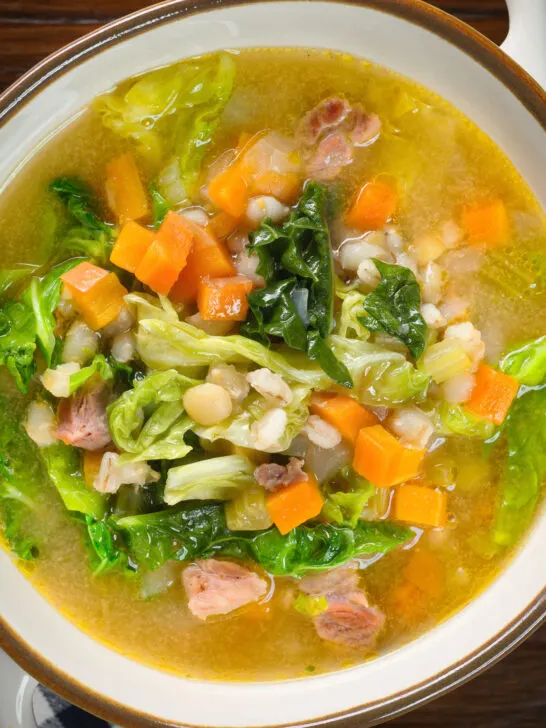 Overhead close-up Scotch broth soup with lamb, pearl barley and savoy cabbage.
