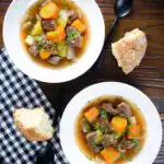 Overhead slow cooker Irish stew with lamb, potatoes carrots and onions served with soda bread.