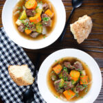 Overhead slow cooker Irish stew with lamb, potatoes carrots and onions served with soda bread.