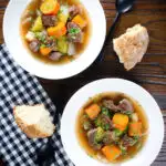 Overhead slow cooker Irish stew with lamb, potatoes carrots and onions served with soda bread.