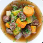 Overhead close-up slow cooker Irish stew with lamb, potatoes carrots and onions.