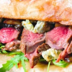Close-up steak, stilton, caramelised onion and rocket sandwich served on ciabatta.