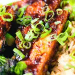 Close-up spicy fried tofu with black bean sauce and tenderstem broccoli served with egg fried rice.