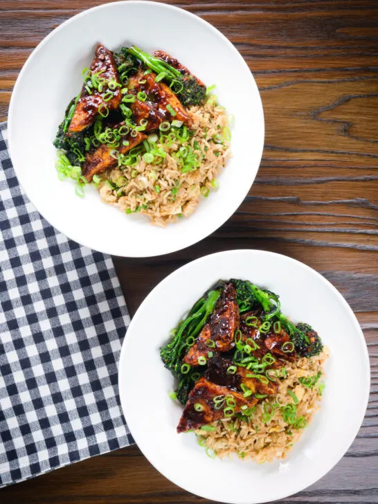 Overhead spicy fried tofu with black bean sauce and tenderstem broccoli served with egg fried rice.