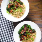 Overhead spicy fried tofu with black bean sauce and tenderstem broccoli served with egg fried rice.