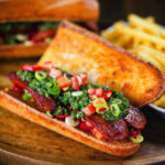 Argentinian-Influenced choripan sandwich with Spanish chorizo, chimichurri and salsa