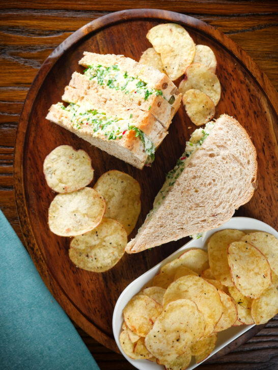 Overhead canned crab sandwiches with coriander, lime and chilli mayonnaise serve with crisps.