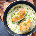 Creamy tarragon chicken breasts in a vermouth sauce in a pan.