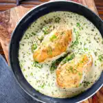Creamy tarragon chicken breasts in a vermouth sauce in a pan.