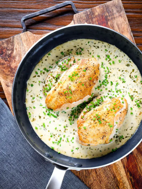 Creamy tarragon chicken breasts in a vermouth sauce in a pan.