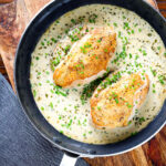 Creamy tarragon chicken breasts in a vermouth sauce in a pan.