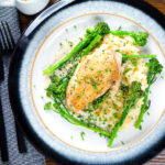 Overhead creamy tarragon chicken breasts served with celeriac mash and tenderstem broccoli.