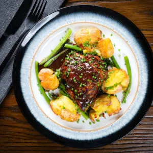 Devilled chicken thighs with roasted crushed new potatoes and green beans.