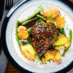 Overhead devilled chicken thighs served with roasted new potatoes, green beans and chives.