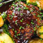 Overhead close-up devilled chicken thighs served with roasted new potatoes, green beans and chives.