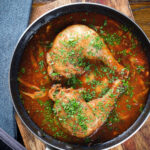 Overhead chicken chasseur or French hunters chicken with mushrooms in a wine sauce.