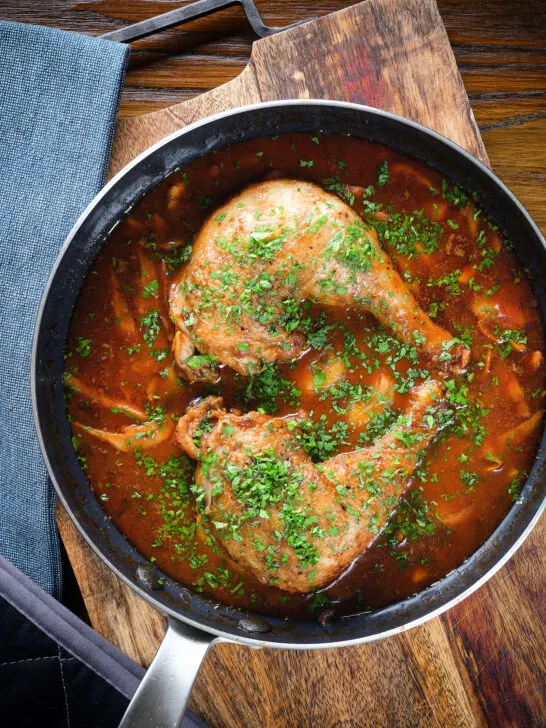 Overhead chicken chasseur or French hunters chicken with mushrooms in a wine sauce.