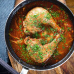 Overhead chicken chasseur or French hunters chicken with mushrooms in a wine sauce.