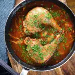 Overhead chicken chasseur or French hunters chicken with mushrooms in a wine sauce.