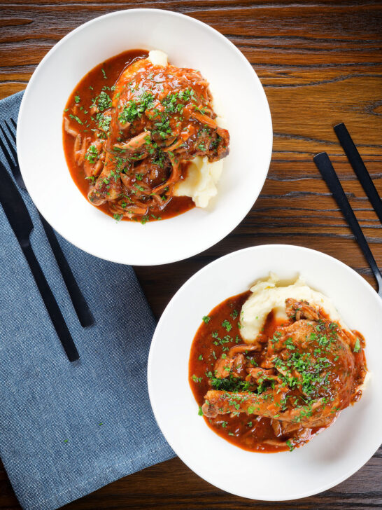 Overhead chicken chasseur or French hunters chicken served with mashed potato in two bowls.