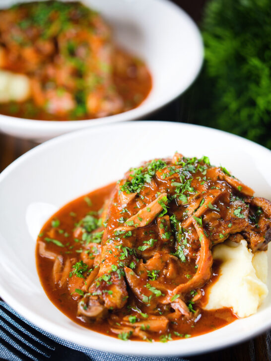 Chicken chasseur or French hunters chicken served with mashed potato in two bowls.