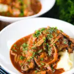 Chicken chasseur or French hunters chicken served with mashed potato in two bowls.