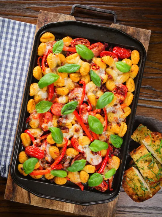 Overhead gnocchi tray bake with sun-dried and fresh tomatoes, mozzarella and pickled chilli.