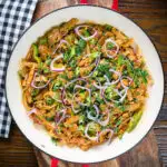 Overhead homemade Sri Lankan chicken kottu (kotthu) roti served in a cooking pan.
