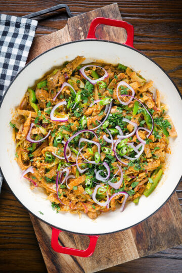 Overhead homemade Sri Lankan chicken kottu (kotthu) roti served in a cooking pan.