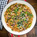 Overhead homemade Sri Lankan chicken kottu (kotthu) roti served in a cooking pan.