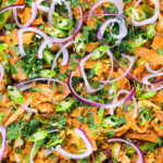 Overhead close-up homemade Sri Lankan chicken kottu (kotthu) roti served in a cooking pan.