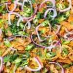 Overhead close-up homemade Sri Lankan chicken kottu (kotthu) roti served in a cooking pan.