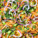 Overhead close-up homemade Sri Lankan chicken kottu (kotthu) roti served in a cooking pan.