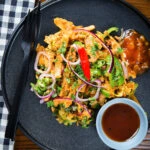 Overhead homemade Sri Lankan chicken kottu (kotthu) roti served on a plate with chutneys.