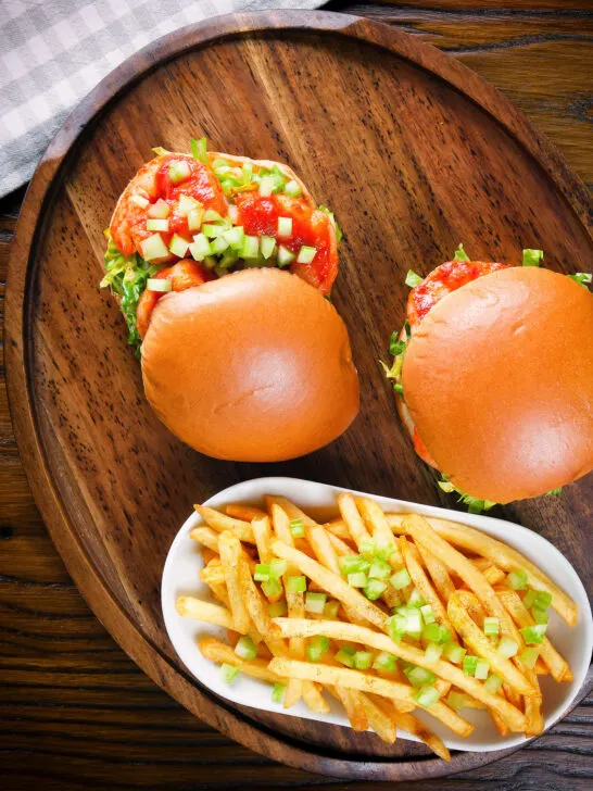 Overhead prawn sandwich with a bloody Mary sauce and celery on a brioche bun served with French fries.