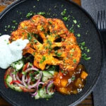 Overhead roasted tandoori cauliflower steak with kachumber salad, mango chutney and mint raita.