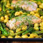 Salmon fillet tray bake with pesto, green veggies and gnocchi served on a sheet pan.