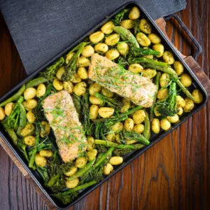 Salmon fillet traybake with gnocchi, basil pesto, asparagus, sugar snap peas and broccoli.