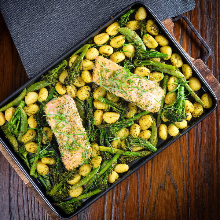 Salmon fillet traybake with gnocchi, basil pesto, asparagus, sugar snap peas and broccoli.
