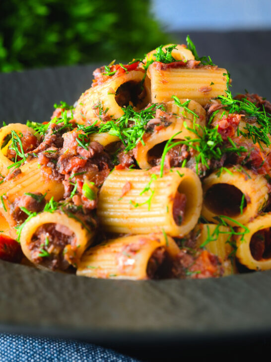 Sardine and tomato pasta (rigatoni) Bolognese or ragu garnished with fresh basil.