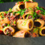 Sardine and tomato pasta (rigatoni) Bolognese or ragu garnished with fresh basil.