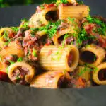 Sardine and tomato pasta (rigatoni) Bolognese or ragu garnished with fresh basil.