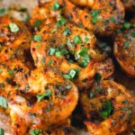 Close-up Indian tandoori king prawns skewers served with chapatis.