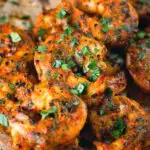 Close-up Indian tandoori king prawns skewers served with chapatis.