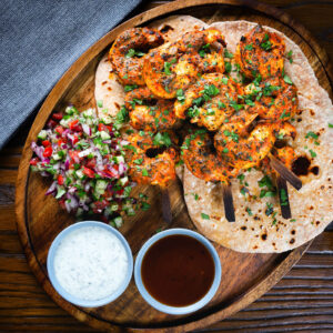 Indian tandoori king prawns with chapatis, kachumber salad, mint raita and tamarind chutney.